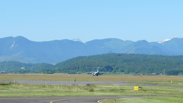 Military Turboprop Transport Airplane Taking Off, Mountain Background.