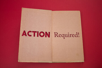Action Required word in opened book with vintage, natural patterns old antique paper design.