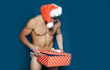 Christmas sexy man. Young men in santa hat. New year. Muscle man at xmas. Santa with muscular body....
