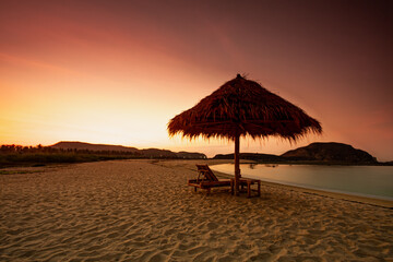 Beautiful tropical beach in kuta Lombok with wooden chair and sunbeds/ umbrella