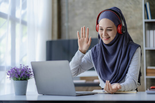 
Muslim female student in hijab studying online with laptop Asian girl in headphones doing homework with digital tablet teaching online Muslim female teacher is making a video call.