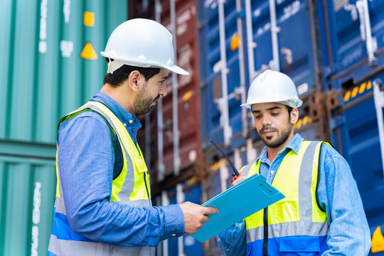 Two male engineers in a container shipping company Consulting to check the order for the container that is responsible	
