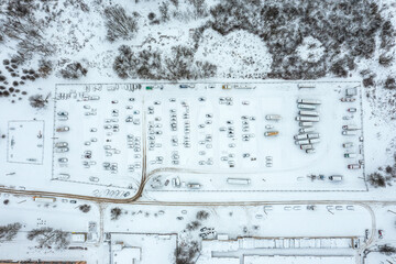 birds eye view of parked cars on outdoor parking lot after snowfall in winter. drone aerial photo.