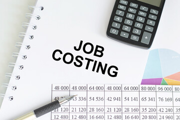 JOB COSTING text on a paper with keyboard, calculator on white background