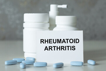Card with word Rheumatism Arthritis and pills on white table