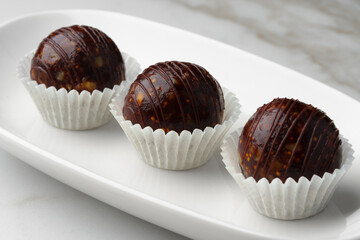 Three chocolate candies sweets on white plate