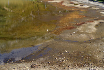 Oberalppass with lake and lake shore with reflections of mountain panorama on a sunny late summer day. Photo taken September 5th, 2022, Oberalppass, Switzerland.