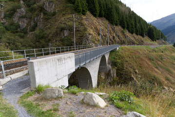 Fototapeta premium Railway bridge at Swiss mountain pass Oberalppass on a cloudy late summer day. Photo taken September 5th, 2022, Oberalp Pass, Switzerland. 