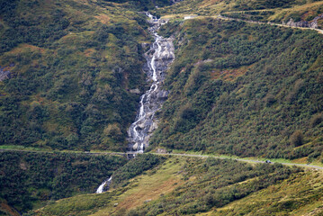 Aerial view over scenic landscape with river at Swiss mountain pass Oberalppass on a blue cloudy late summer morning. Photo taken September 5th, 2022, Oberalp Pass, Switzerland.