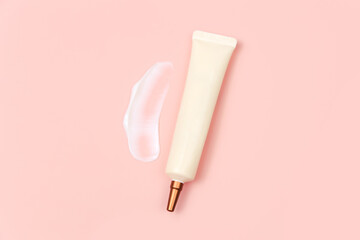 Mockup of face and eye cream squeeze cosmetic tube with long nozzle and bronze screw cap and big smear of moisturizer on pink background. Natural organic spa cosmetics concept, flat lay, top view.