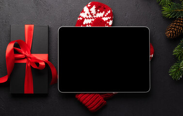Tablet with blank screen, gift box and Christmas decor