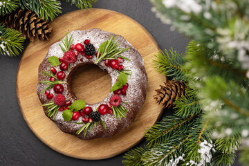 Christmas cake with pomegranate seeds, cranberries and rosemary