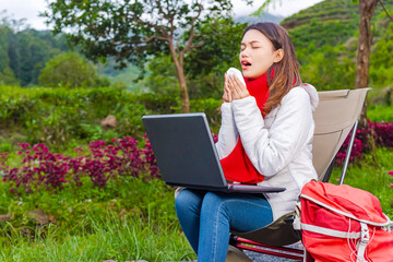Asian woman with a laptop gets flu while enjoying camp activities
