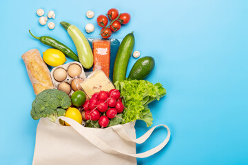Shopping bag full of healthy food on blue