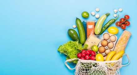 Shopping bag full of healthy food on blue