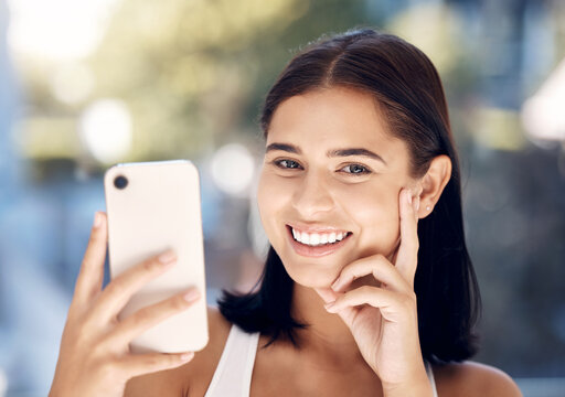 Phone, selfie and portrait of a woman in a bathroom for skincare, beauty and cleaning against blurred background mockup. Face, girl and smile for picture after facial treatment, grooming and hygiene