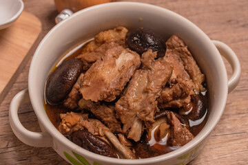 Braised pork ribs with shiitake mushrooms on wooden background