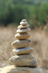 Fototapeta na wymiar Stone chairn. Zen stones in the field. stack of stones in a pyramid, top view