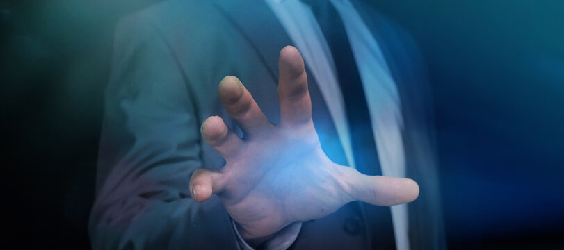 Businessman touching imaginary screen with open hand.