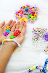Set of multi-colored beads for needlework, child making jewelry at home. Easy and creative craft for children and teenagers