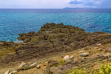 Fototapeta na wymiar Turquoise surface of sea water and beach in Greece before the rain