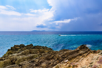 Turquoise surface of sea water and beach in Greece before the rain