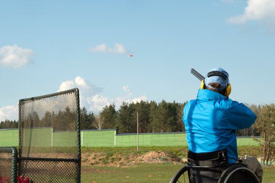 a shooter in a wheelchair shoots clay pigeon , skeets in a shooting club