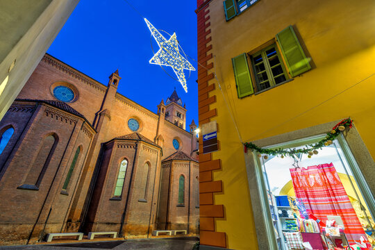 San Lorenzo cathedral, star shaped Christmas decoration and building in the evening in Alba, Italy.