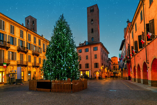 Illuminated Christmas tree on small town square in Alba, Italy.