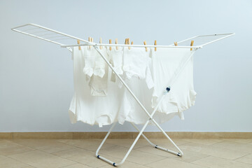 Drying rack with different clothes staying in room