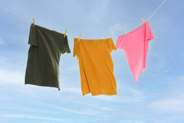 T-shirts hanging on twine on sky background