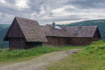 Fototapeta na wymiar Old hunting wooden cottage in Jeseniky mountains on a summer cloudy day