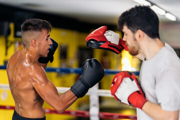 Professional trainer with mitten with boxer on ring