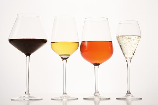 Pink, white, red, sparkling alcoholic drinks in wine glasses.