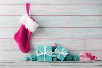 Gift boxes and pink Santa’s stocking hanging on wooden background - 548160316