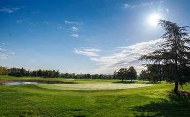 Green golf course against blue sky
