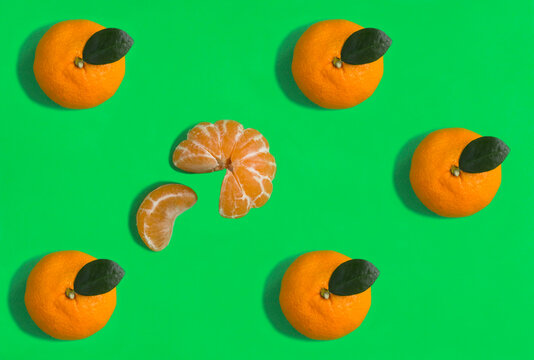Tangerine on the green background. Flat lay. Pattern. Top view.