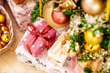 boxes with gifts on the Christmas tree with classic decorations.