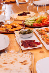 Assorted food on the table. Canapes, vegetables, cheeses, sandwiches, olives.
