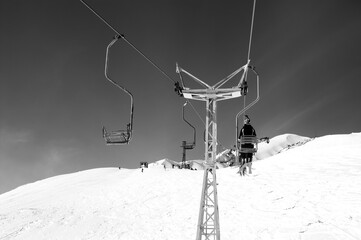 Black and white view on old chair-lift and off-piste slope at ski resort - 548164701