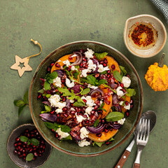 Warm winter quinoa salad with pumpkin, chorizo and mozzarella, arugula leaves and pomegranate.