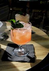 Orange cocktail with mint leaves on a wooden table