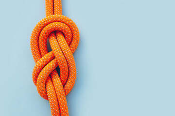 Eight knot on a rope on a blue background close up