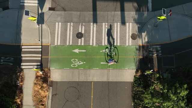 Top down view of a cyclist passing through a vacant intersection using the bike lane.