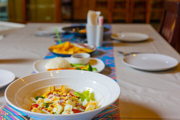 Selective focus shot of well prepared food on table with silverware and plates in restaurant shows concept of event celebration with delicious italian menu (lasagna and salad) for dinner.