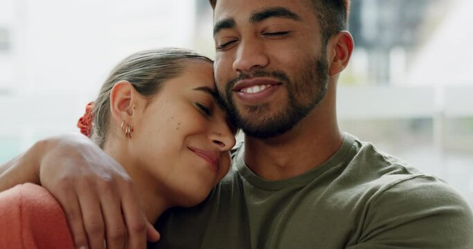 Young couple hugging in home for love, care and romance together in relaxing house. Face of smile, laughing and relax man, woman and people in happy marriage, joyful relationship and sweet happiness