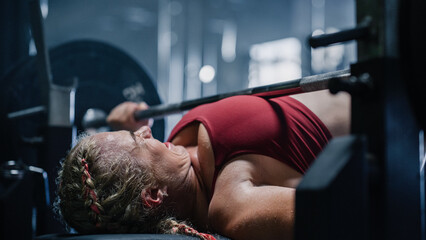 A Persistent Female Bodybuilder Working out, Enduring the Pain of Exercising. Portrait of a Woman...