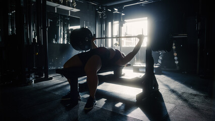  A Resolute Woman Alone in a Hardcore Gym Working out on Her Endurance and Core. Motivated Female...