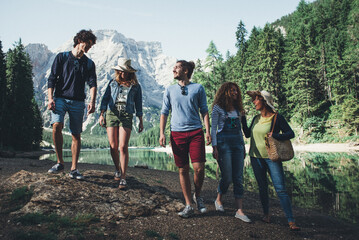 Group of teens spending time on the lake beach