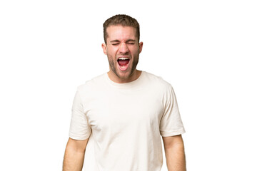 Young handsome caucasian man isolated on green chroma background shouting to the front with mouth wide open